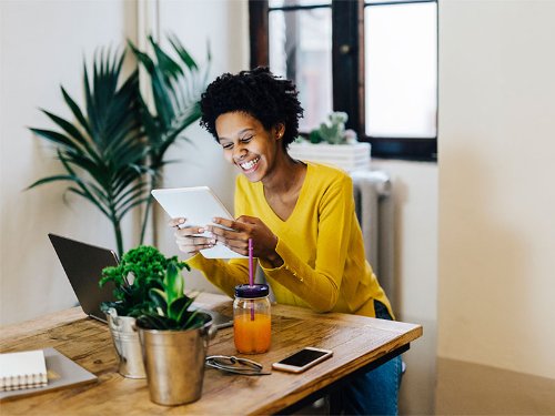 A women laughing while using tablet