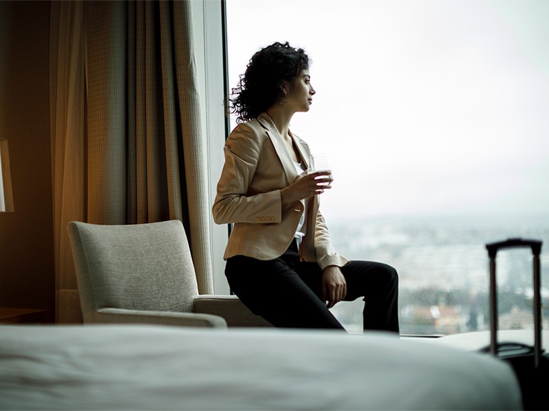 Women Professional having glass of drink while watching outside the glass window