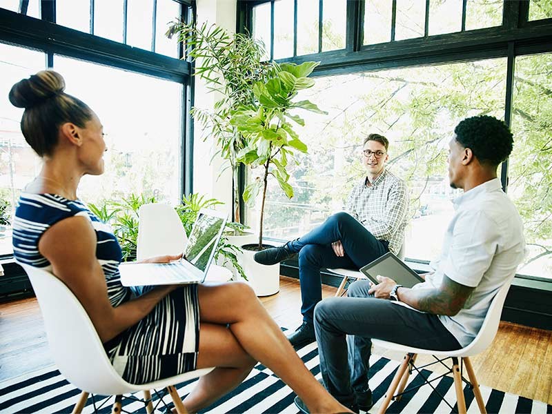 Three people are sitting on the chair