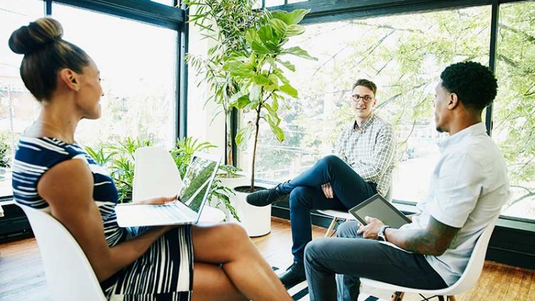 Three people are sitting on the chair