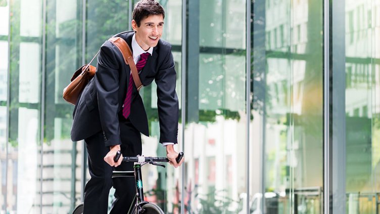 Cheerful young employee riding an utility bicycle in Berlin