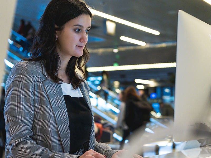 Female programmer or computer administrator working behind computer.