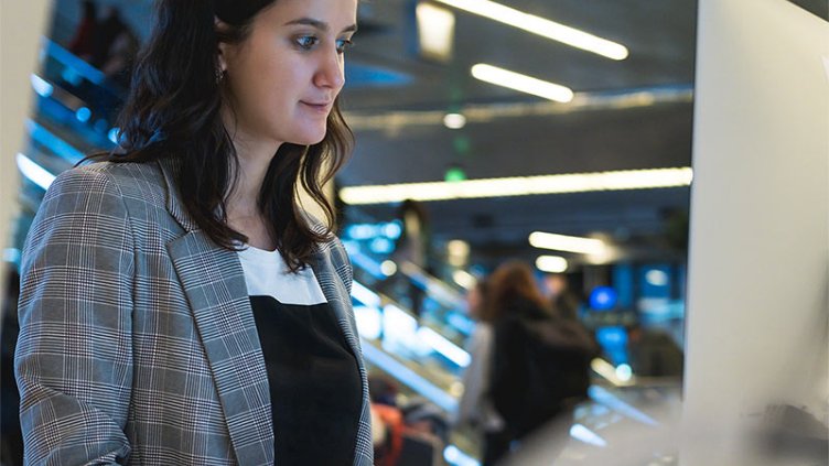 Female programmer or computer administrator working behind computer.