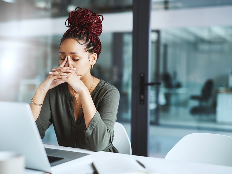 woman looking stressed out while working in an office