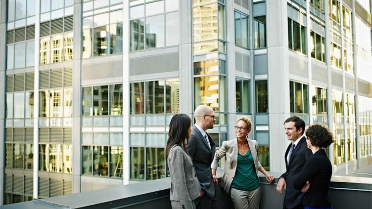 Diverse group of business people in discussion on a terrace in a central business district location