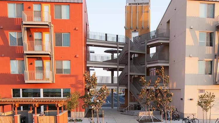 A corner view of an apartment building, strategically located at the intersection of two streets